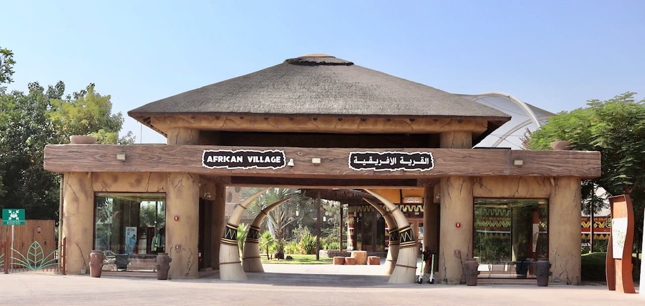 Visitors exploring the African Village zone at Dubai Safari Park with African wildlife and themed landscapes