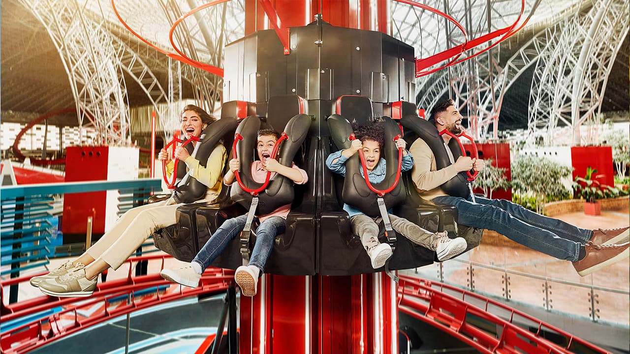 A group of excited children enjoying a thrilling ride in Ferrari World Abu Dhabi.