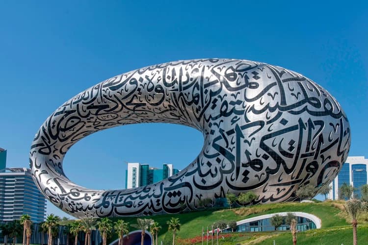 Futuristic silver structure with Arabic calligraphy, shaped like a ring with a hollow center