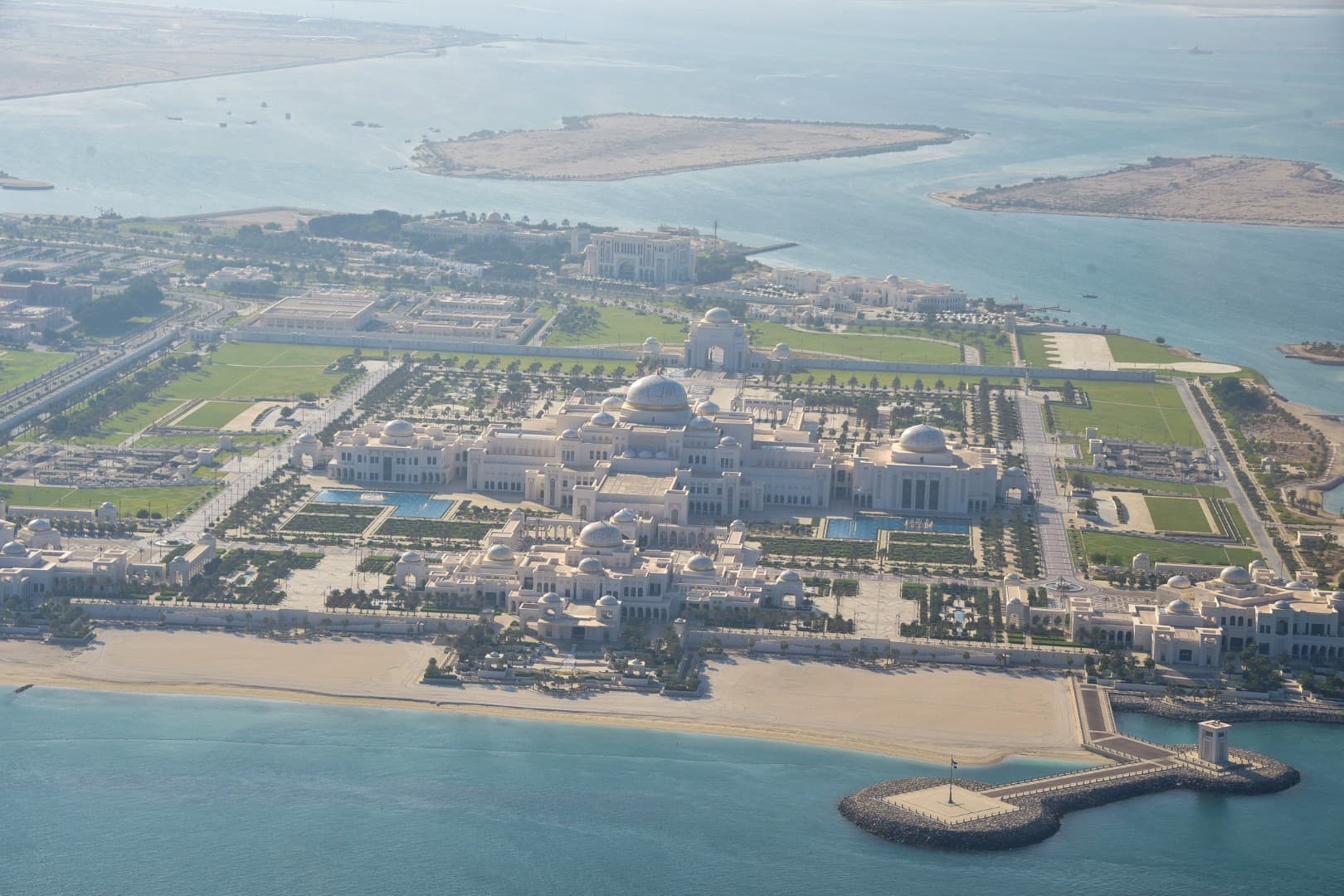 A large building, Emirates Palace, surrounded by water, viewed from a helicopter tour.