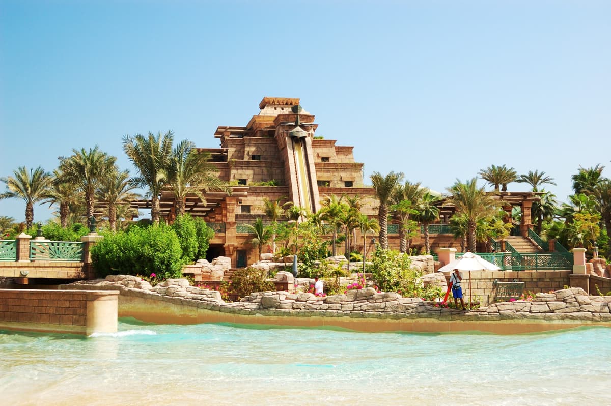 A family joyfully rides a water slide at Atlantis Aquaventure, surrounded by splashes and excitement.