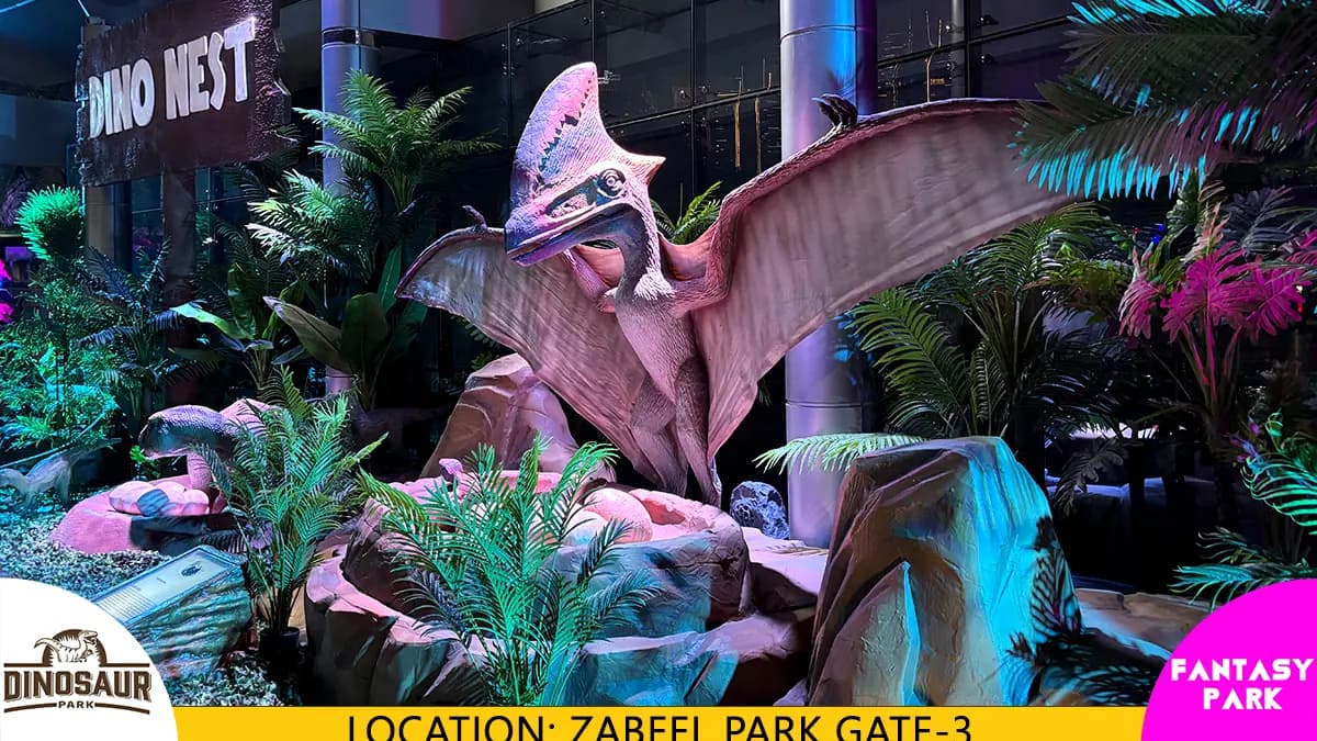 Life-size dinosaur models displayed in a themed outdoor Dinosaur Park with visitors exploring the attraction.
