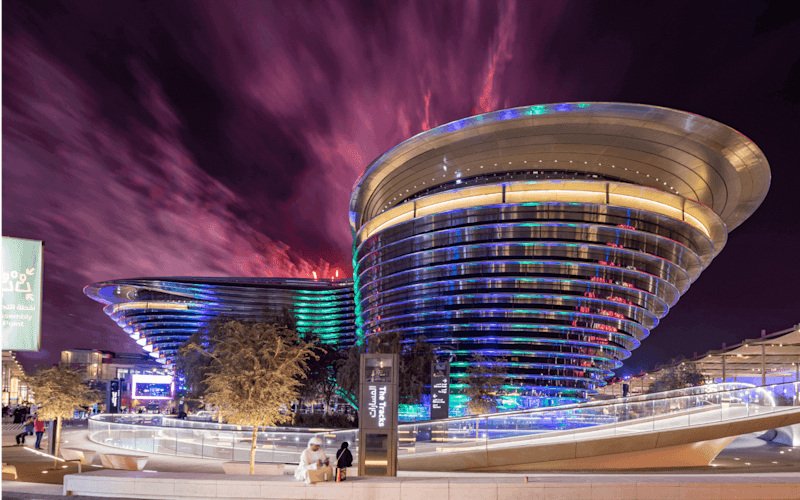 A building with a curved roof under a vibrant sky, showcasing the Alif Pavilion at Expo City Dubai.
