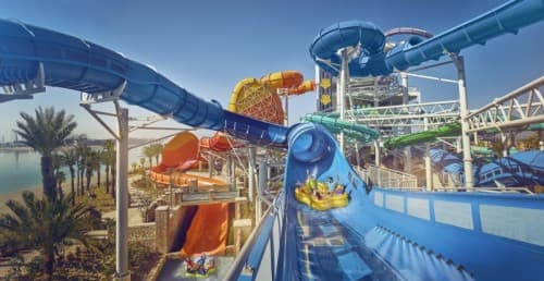 A vibrant water park featuring various slides and attractions at Shark Snorkel Atlantis in Dubai.