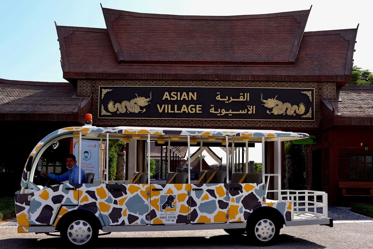 Visitors exploring the Asian Village zone at Dubai Safari Park with themed architecture and wildlife exhibits