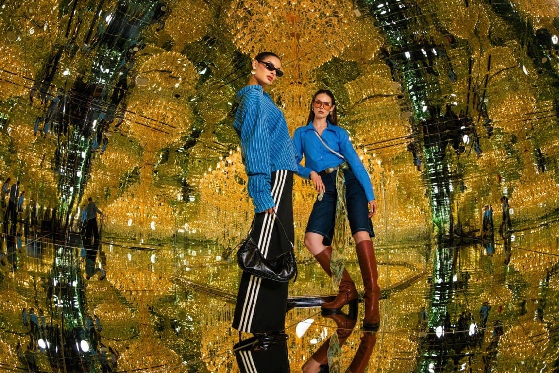 Two people standing in front of a mirror at the House of Hype Dubai Immersive Experience.