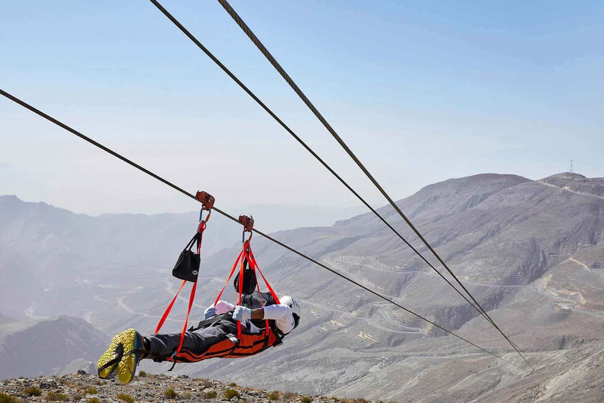 A man glides on a zipline over the mountains during the Jebel Jais Zipline Flight Tour.
