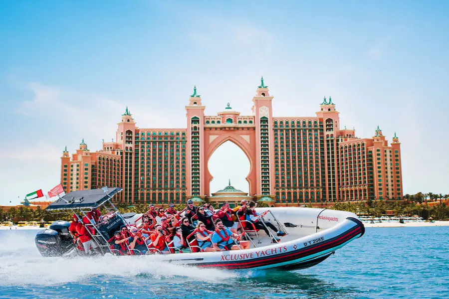 People on a speedboat enjoying a ride in front of the Atlantis The Palm hotel. 