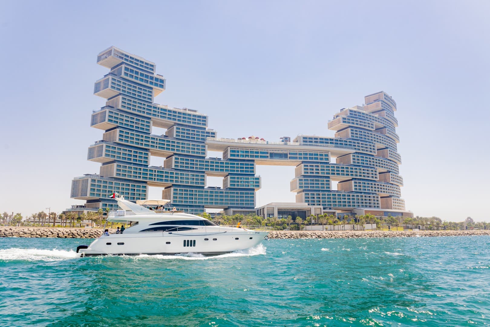 A boat glides through water near the Atlantis Royale building during the Burj Coastline Tour.