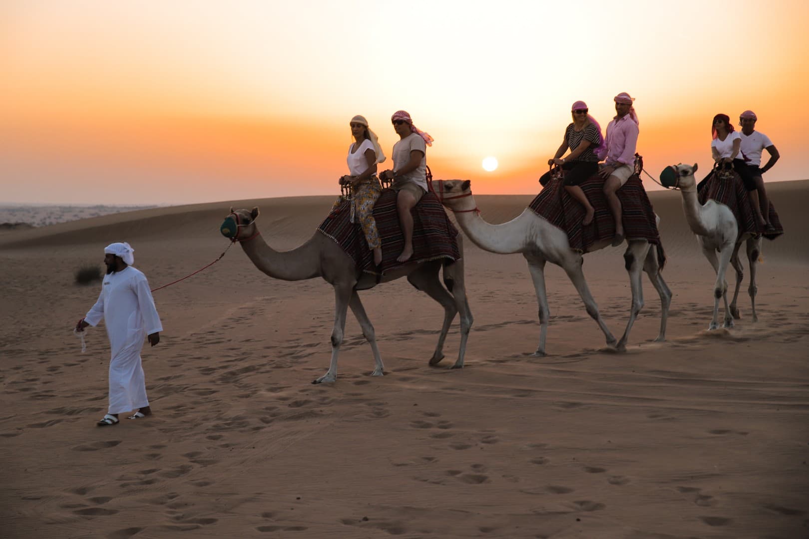 Camel riding adventure across the golden dunes on the Platinum Desert Safari tour in Dubai.