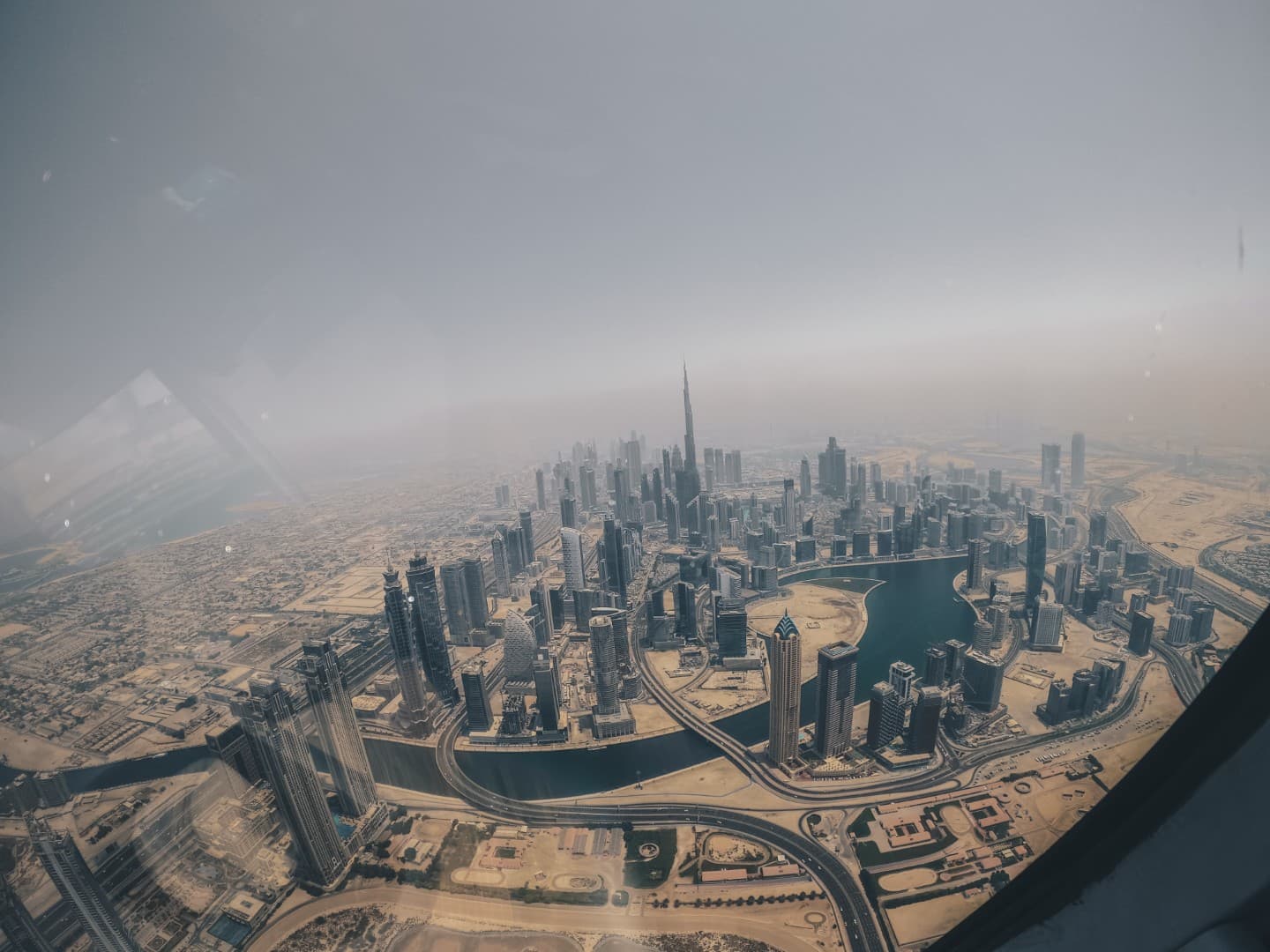 Aerial view of a modern cityscape with skyscrapers surrounding a winding river.