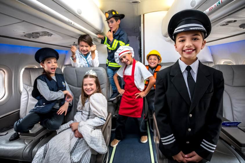 Kids role-playing as pilots and crew inside the airplane experience at KidZania Dubai.