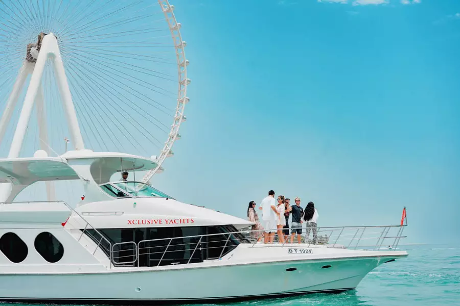 A white yacht with people enjoying a sunny day on deck.