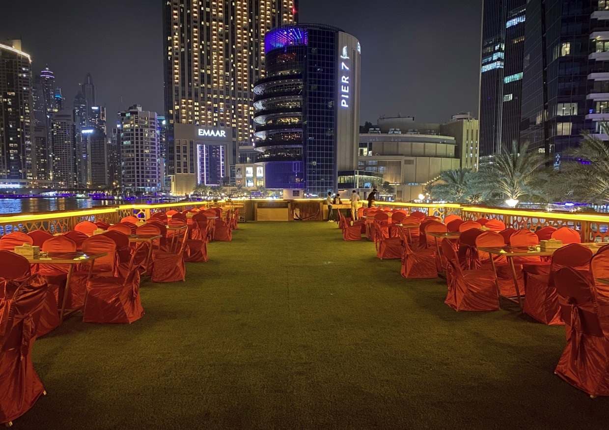 Open-air upper deck seating on a Dubai Mega Dhow dinner cruise
