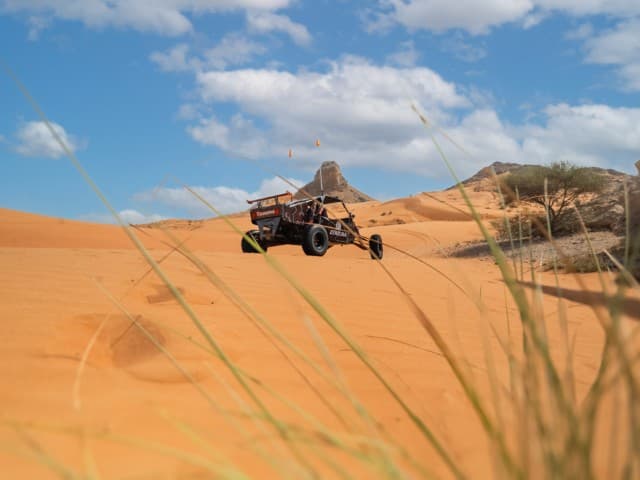 A buggy navigating through sandy dunes during a Mleiha adventure ride.