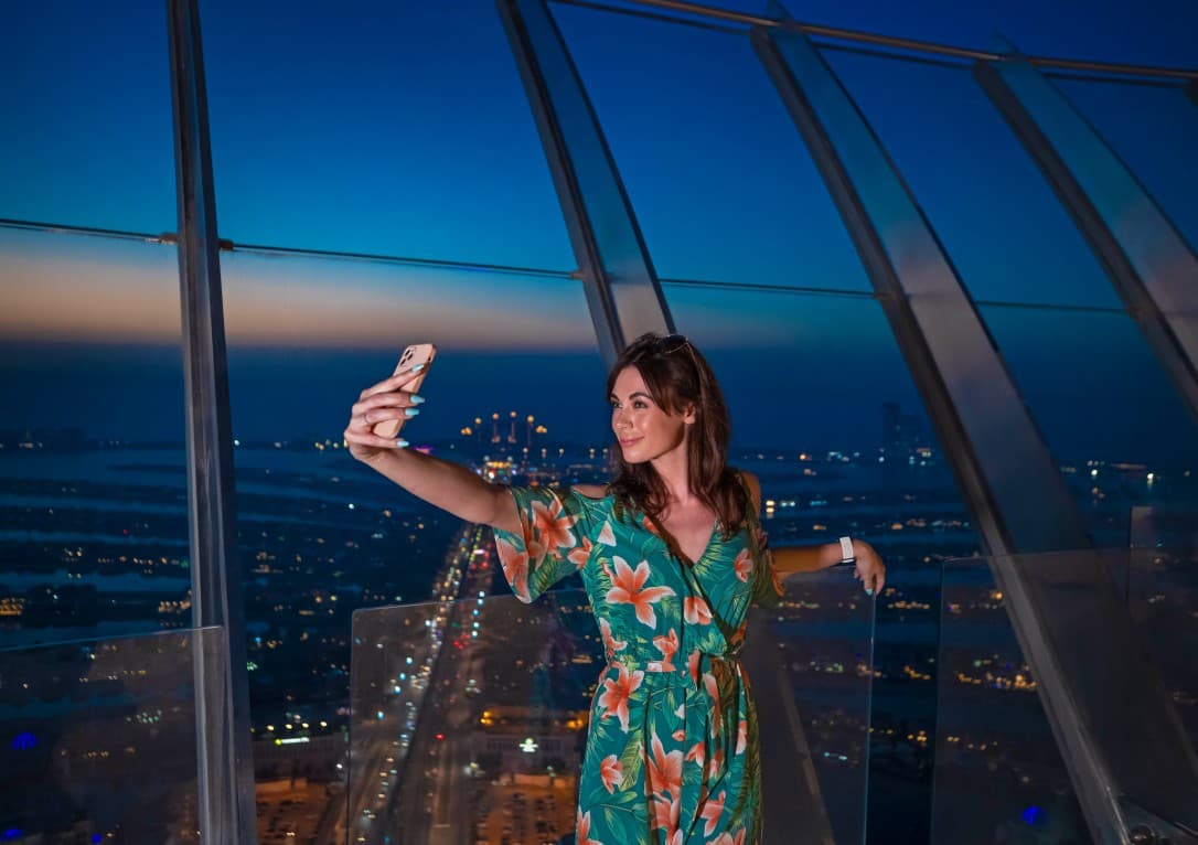 Night view from The View at The Palm Jumeirah observation deck overlooking the illuminated island and Dubai skyline