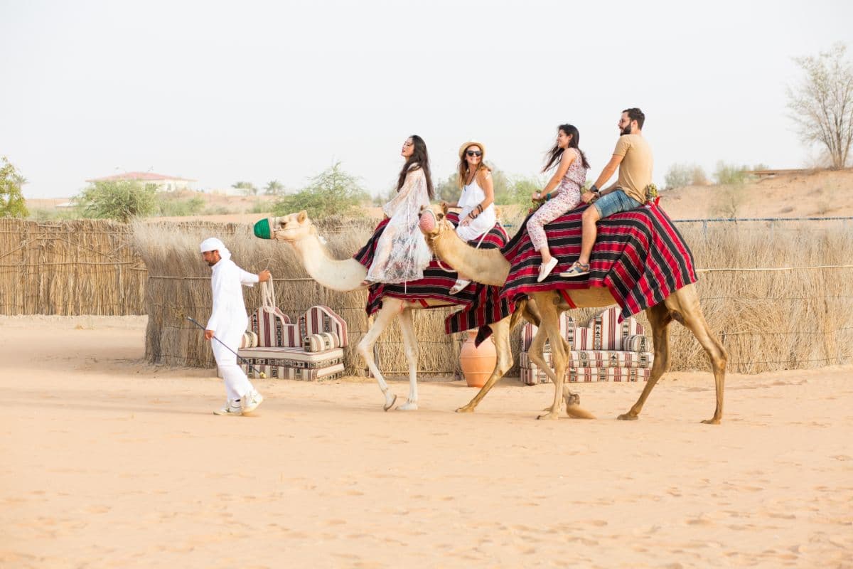 Guest enjoying a camel ride in the Dubai desert as part of the hot air balloon experience.