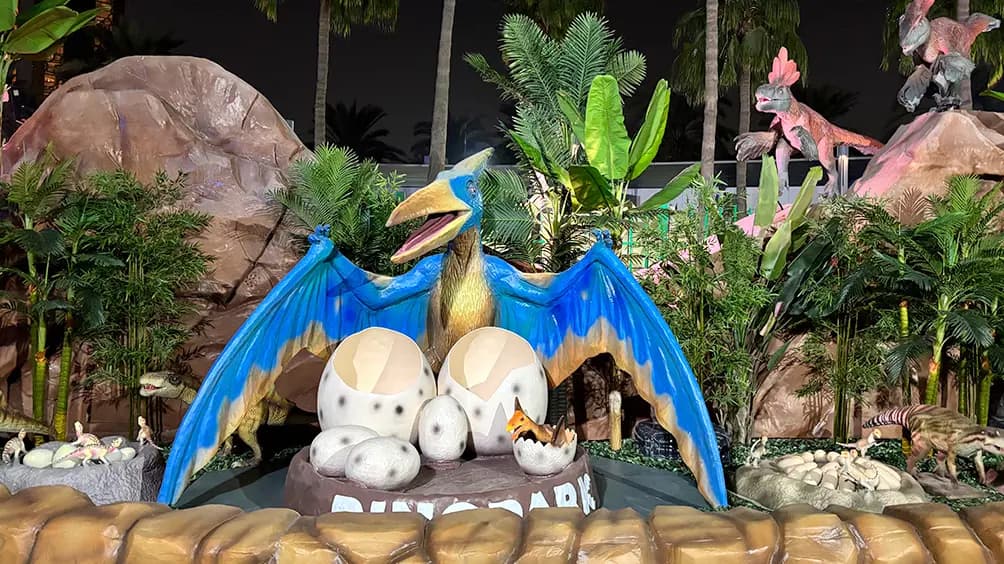Dinosaur model with a nest of eggs displayed at Dinosaur Park, creating a prehistoric-themed scene.