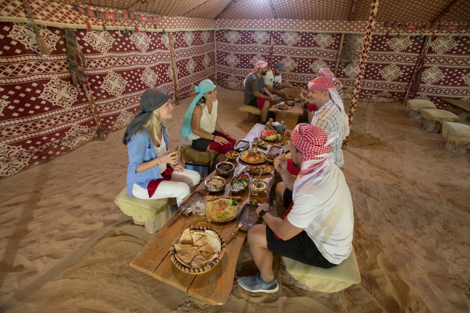 Guests enjoying a traditional Arabic dinner at the Bedouin camp during the Heritage Desert Safari in Dubai.