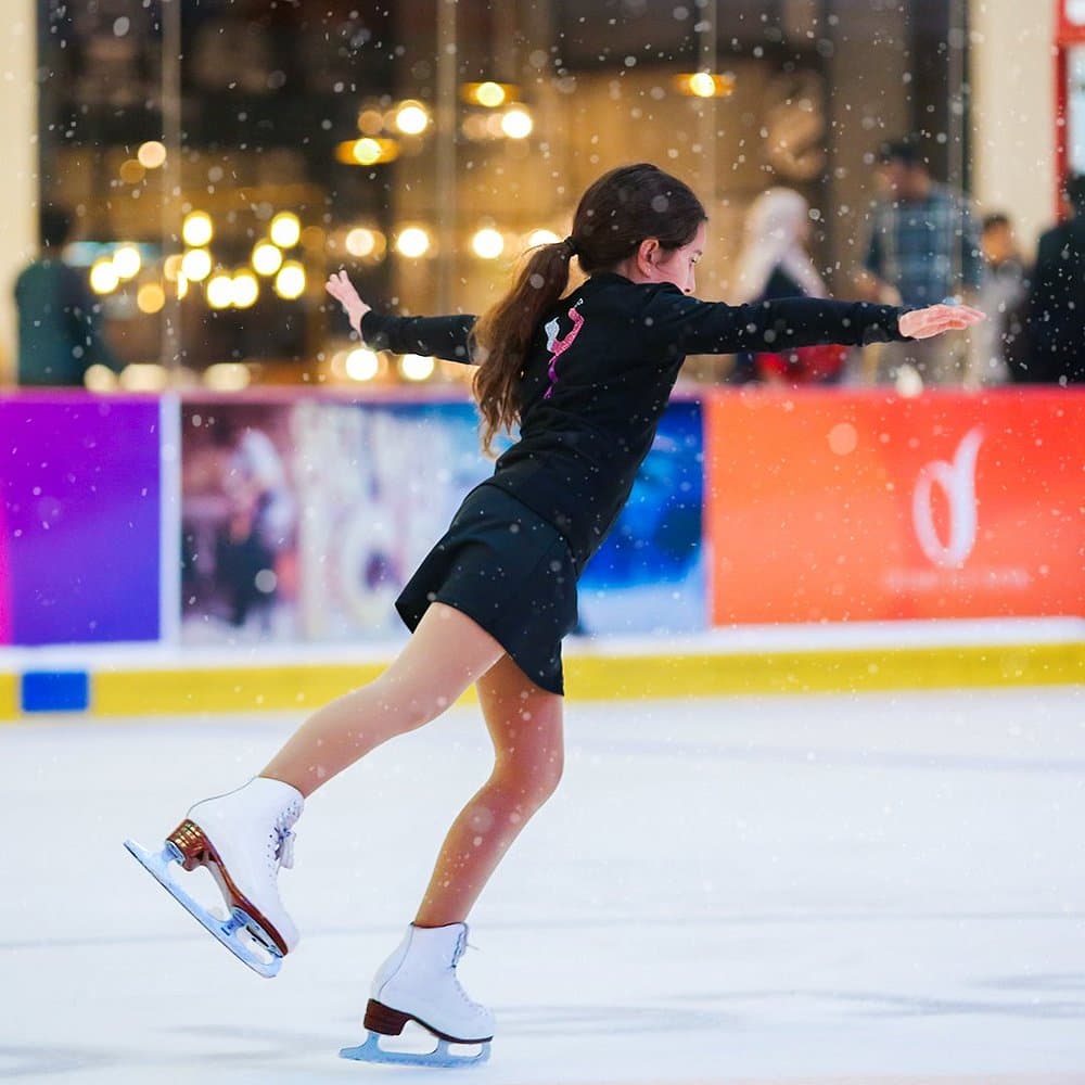 Young girl practicing ice skating at the Dubai Ice Rink, learning and enjoying the indoor arena