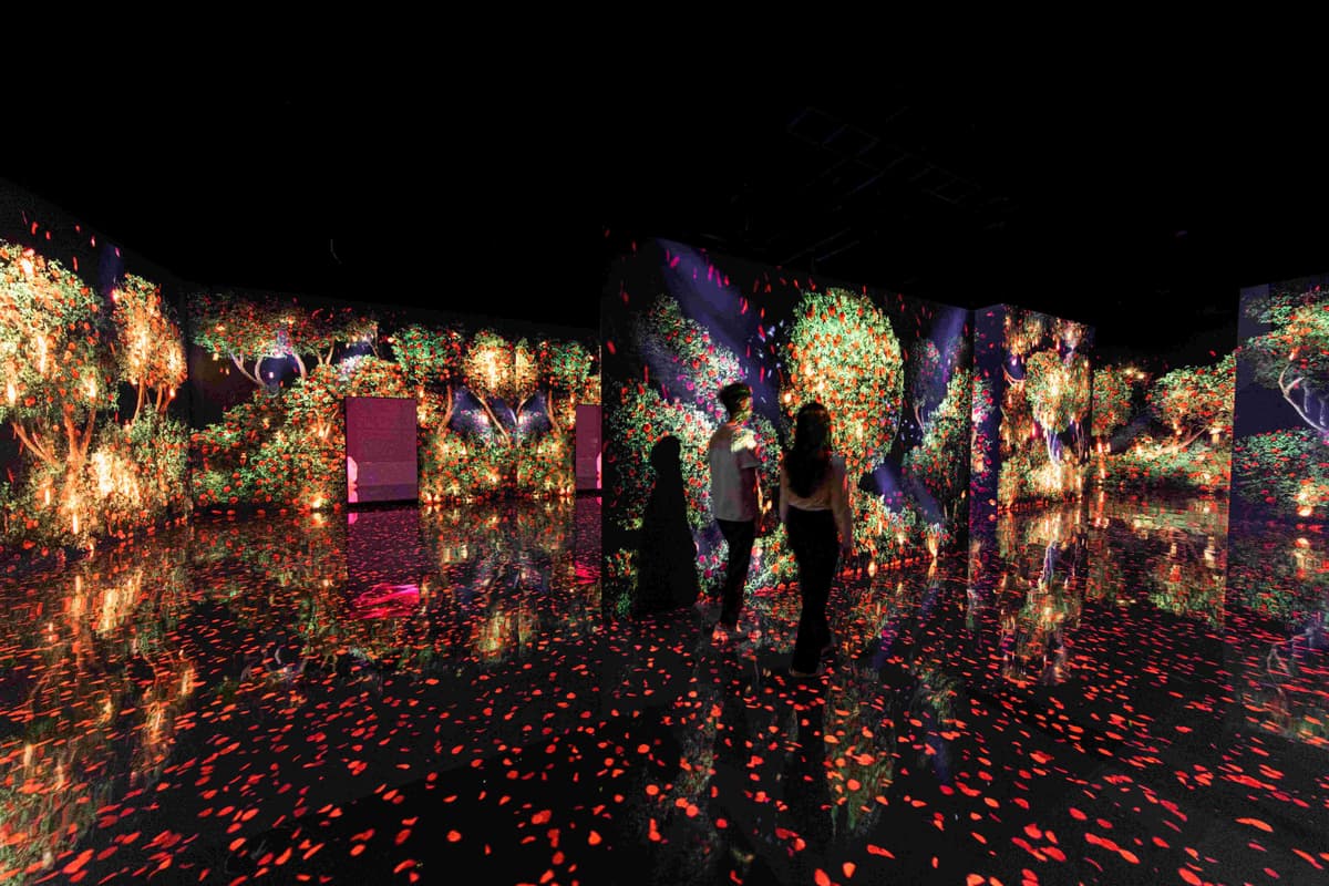 A room at the Arte Museum with guests standing in front of a large illuminated wall of lights.