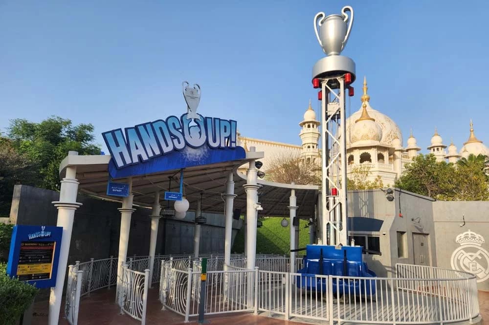 Amusement park ride entrance with "HANDS UP!" sign featuring a trophy design.