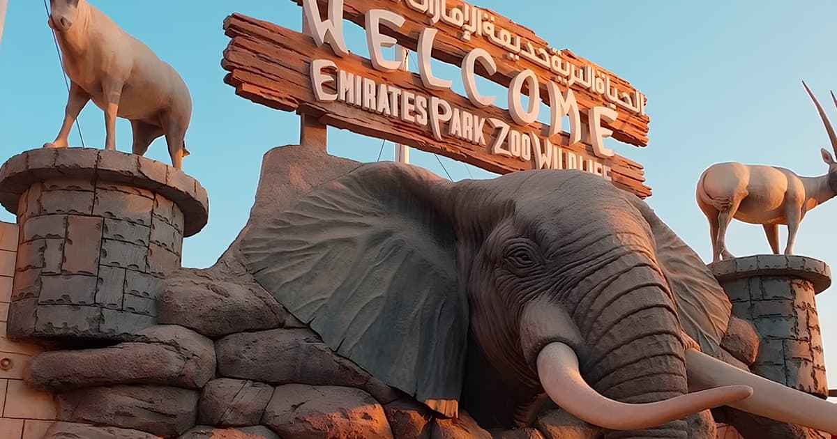 Main entrance of Emirates Zoo Park with visitors arriving and wildlife-themed signage.