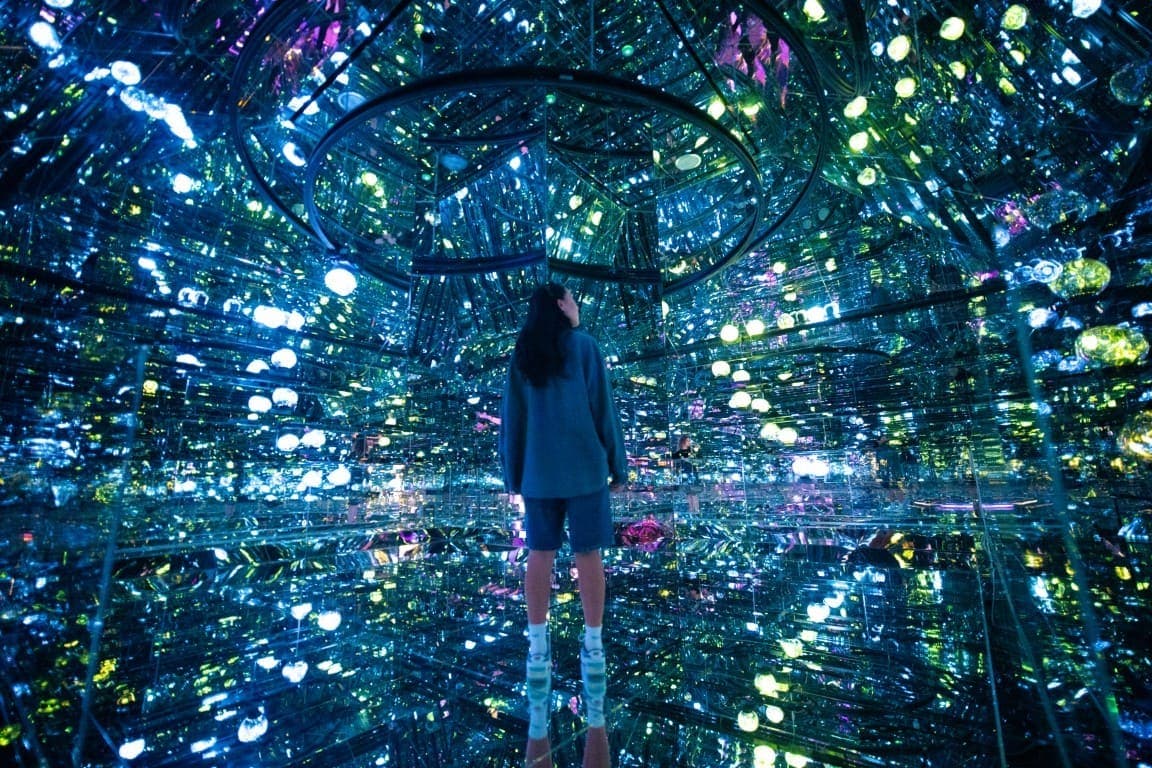 A woman stands in the brightly lit House of Hype in Dubai, surrounded by numerous decorative lights.