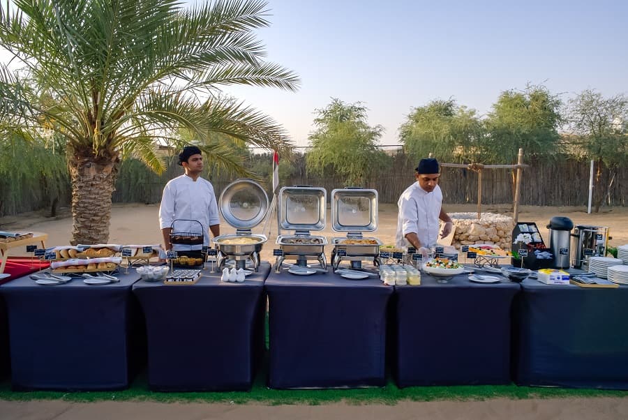 Guests enjoying a buffet breakfast in the desert after a hot air balloon ride in Dubai