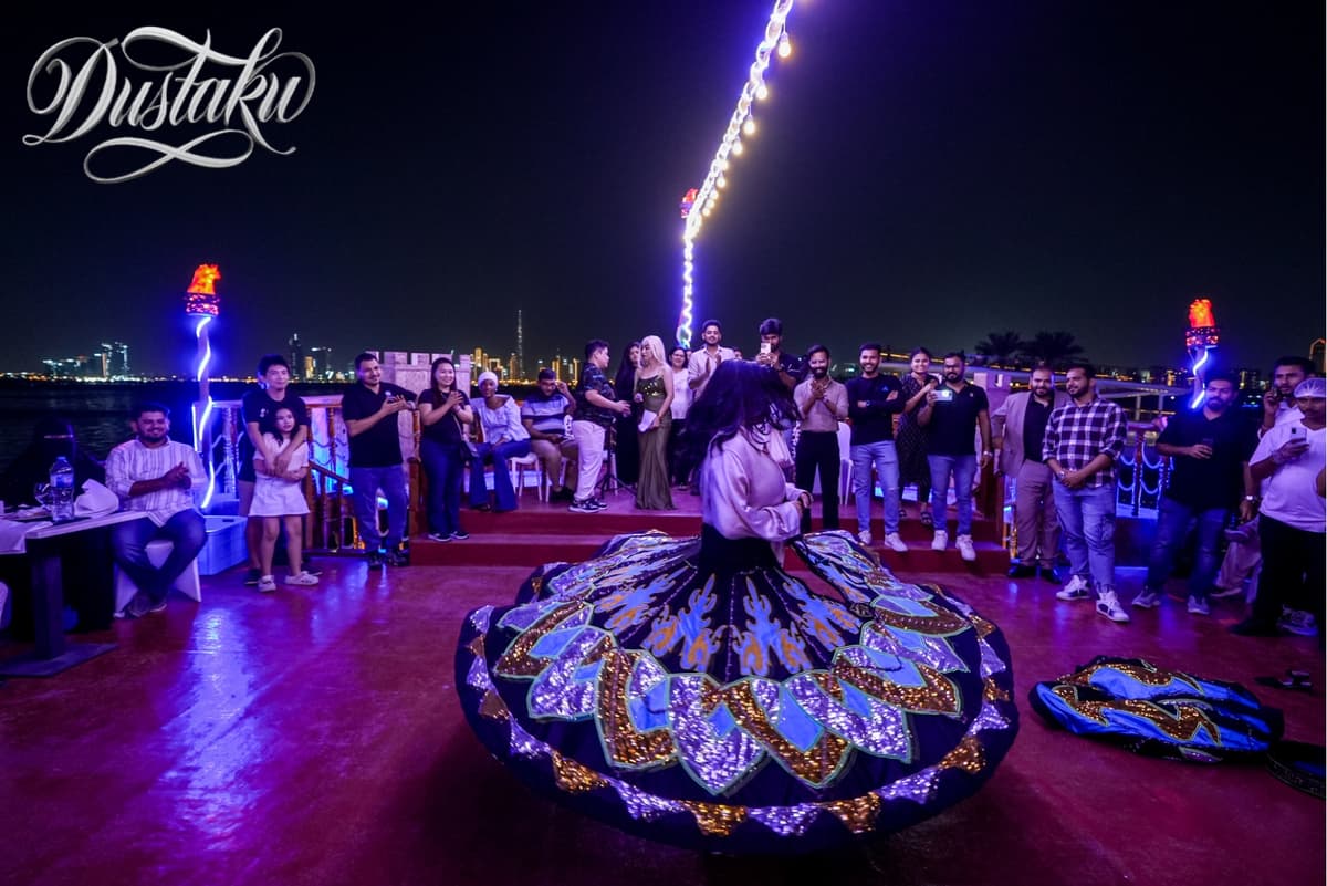 A woman in a colorful dress joyfully dances on a boat during the Dustaku Dinner Dhow Cruise activities.