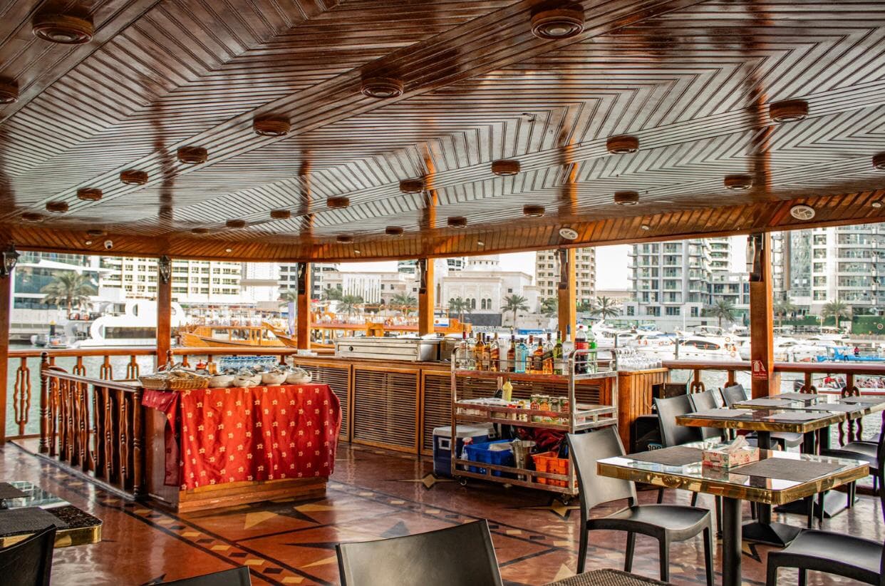 Outdoor seating on dhow cruise with sunset view over Dubai Marina
