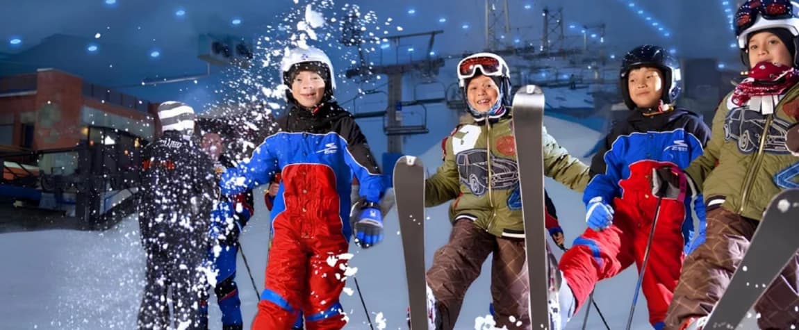 Kids learning and enjoying skiing on the indoor snow slopes at Ski Dubai.