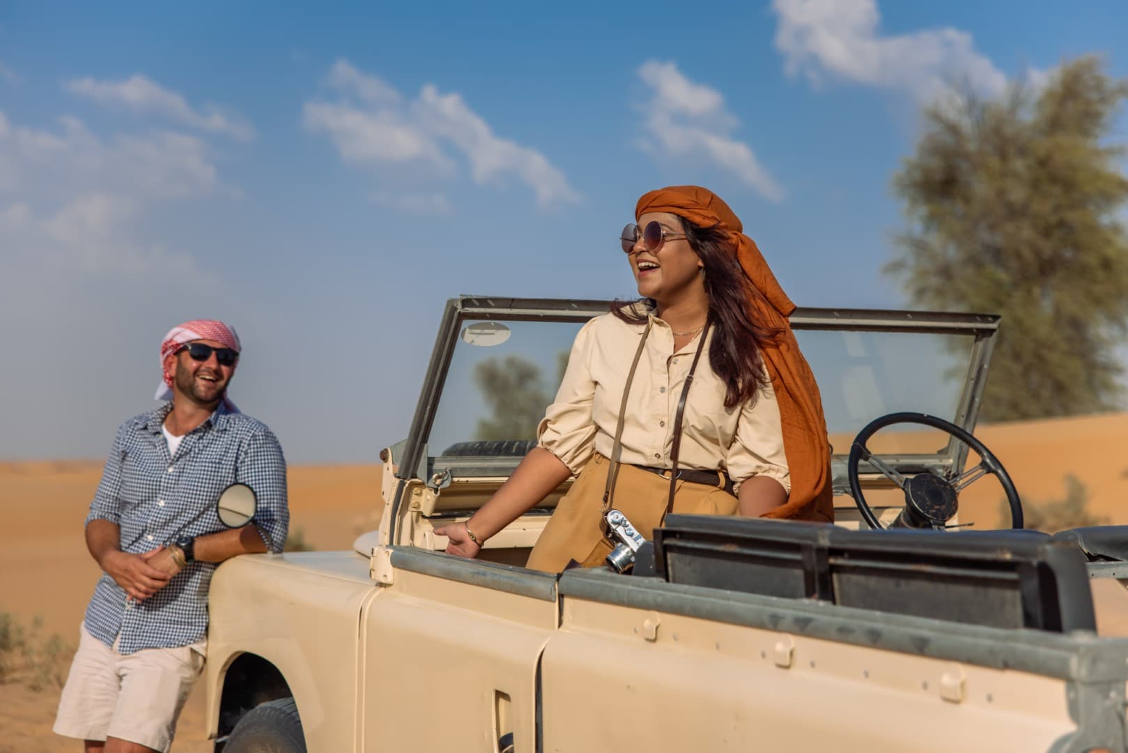 Guests enjoying a vintage Land Rover ride across the Dubai desert during the Heritage Desert Safari experience