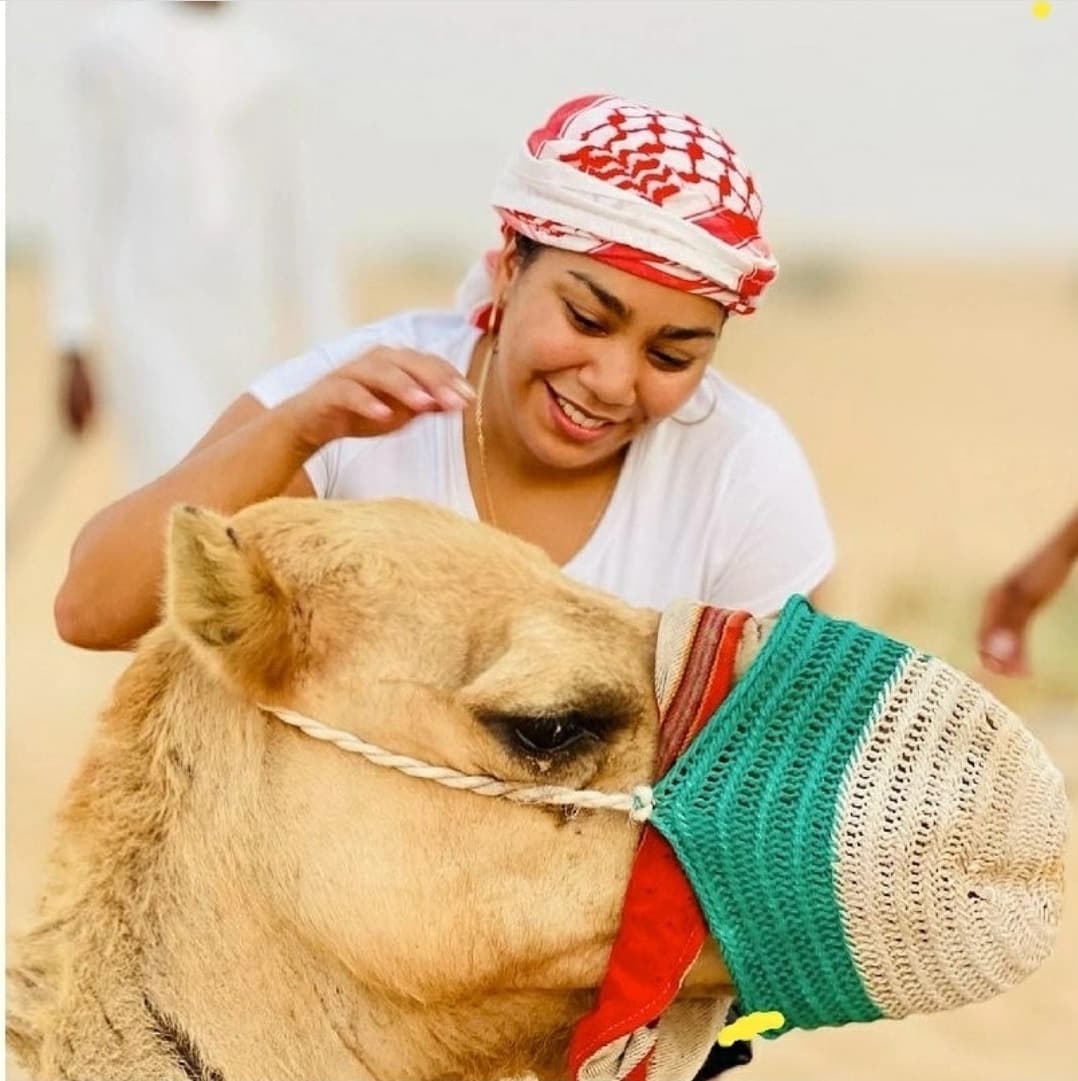 Guests enjoying a camel ride at the desert camp during the Abu Dhabi Desert Safari experience.