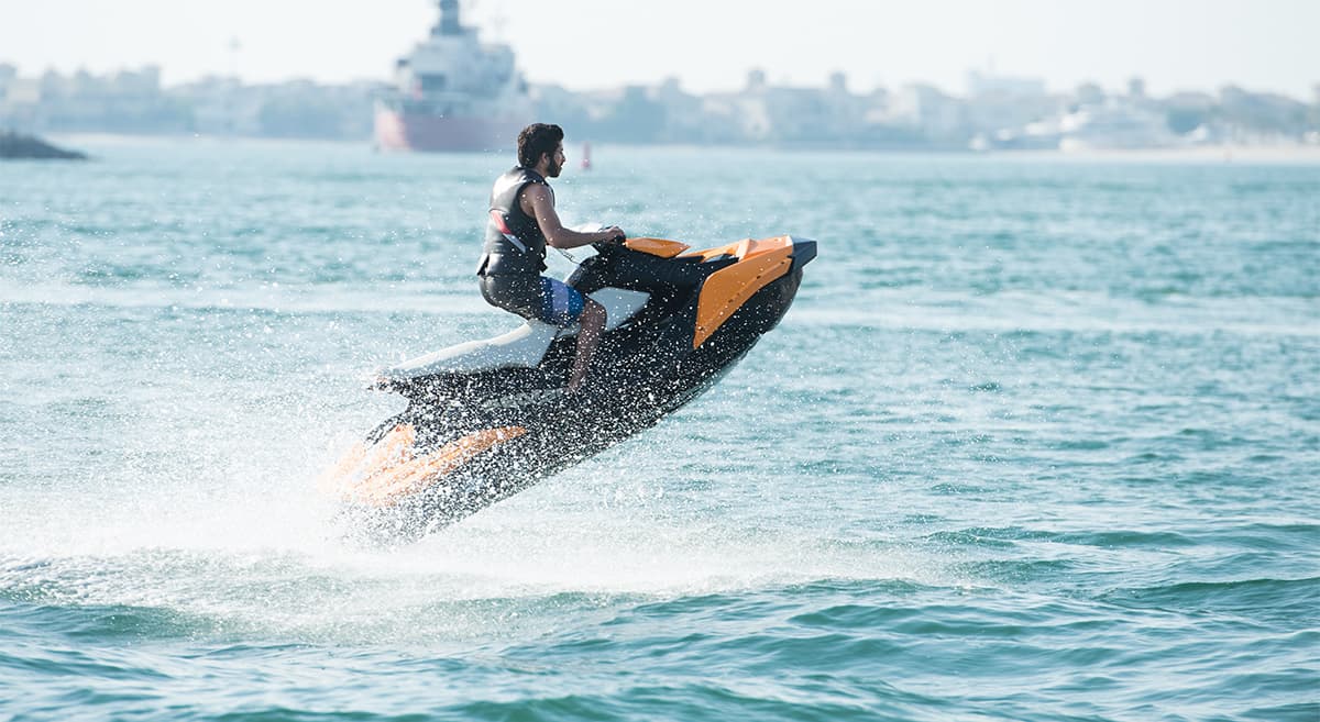A person riding a two-seat jet ski in the ocean during a Jet Ski tour in Dubai.