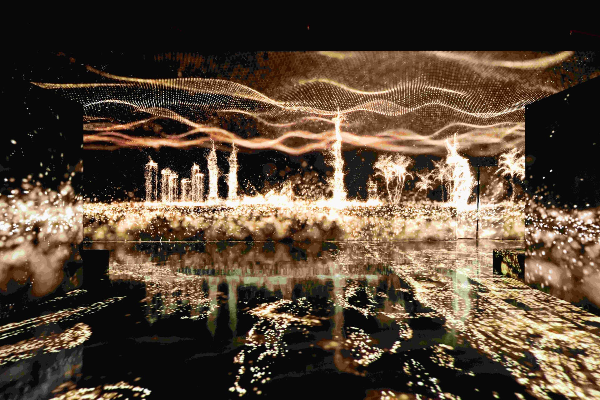 A vibrant cityscape at night, illuminated by lights, with a body of water reflecting the glow, showcasing the Arte Museum.