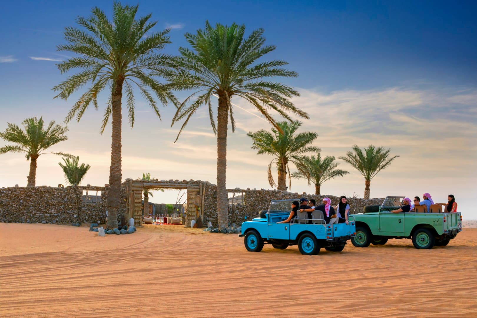 Vintage Land Rover vehicles parked at the Bedouin camp during the Heritage Desert Safari experience in Dubai.