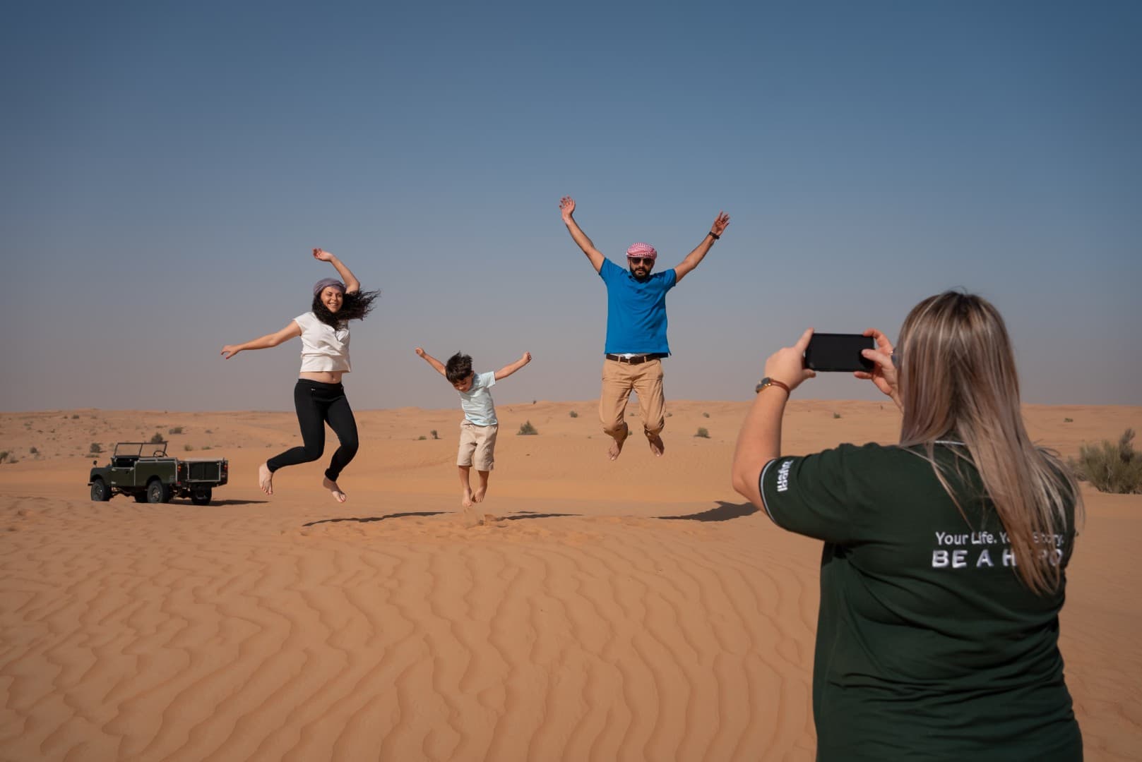 Guests enjoying a desert photoshoot at the Bedouin camp during the Heritage Desert Safari in Dubai.