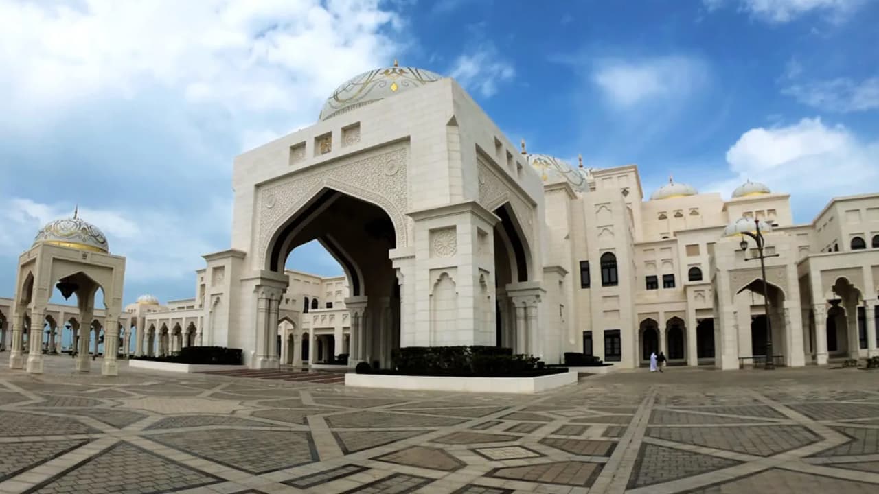 Qasr Al Watan in Abu Dhabi, showcasing stunning white marble architecture and intricate domes under a clear blue sky.