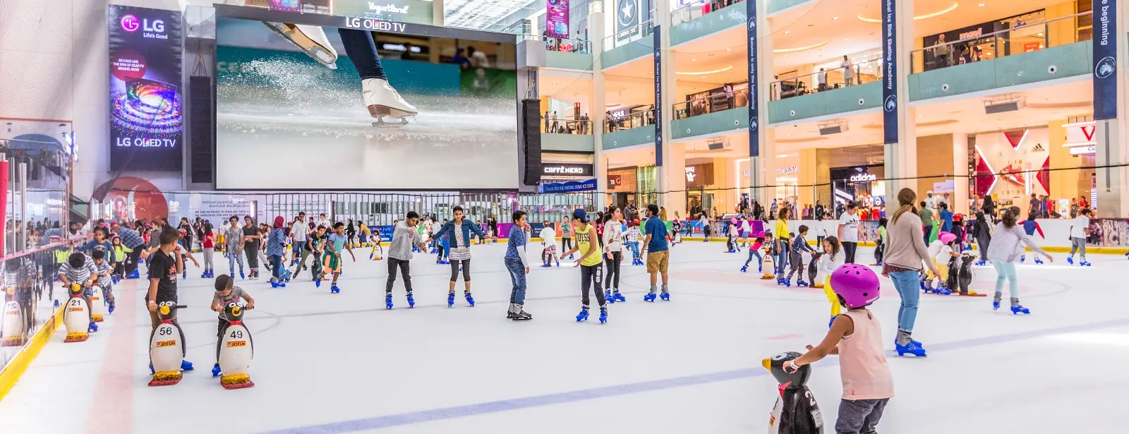 Children enjoying ice skating at the Dubai Ice Rink, having fun on the indoor ice arena