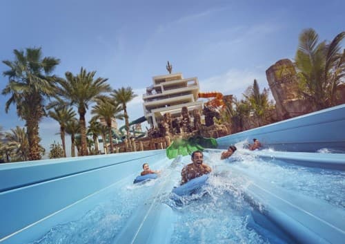 A group of people enjoying a water slide at Atlantis Dubai water park.