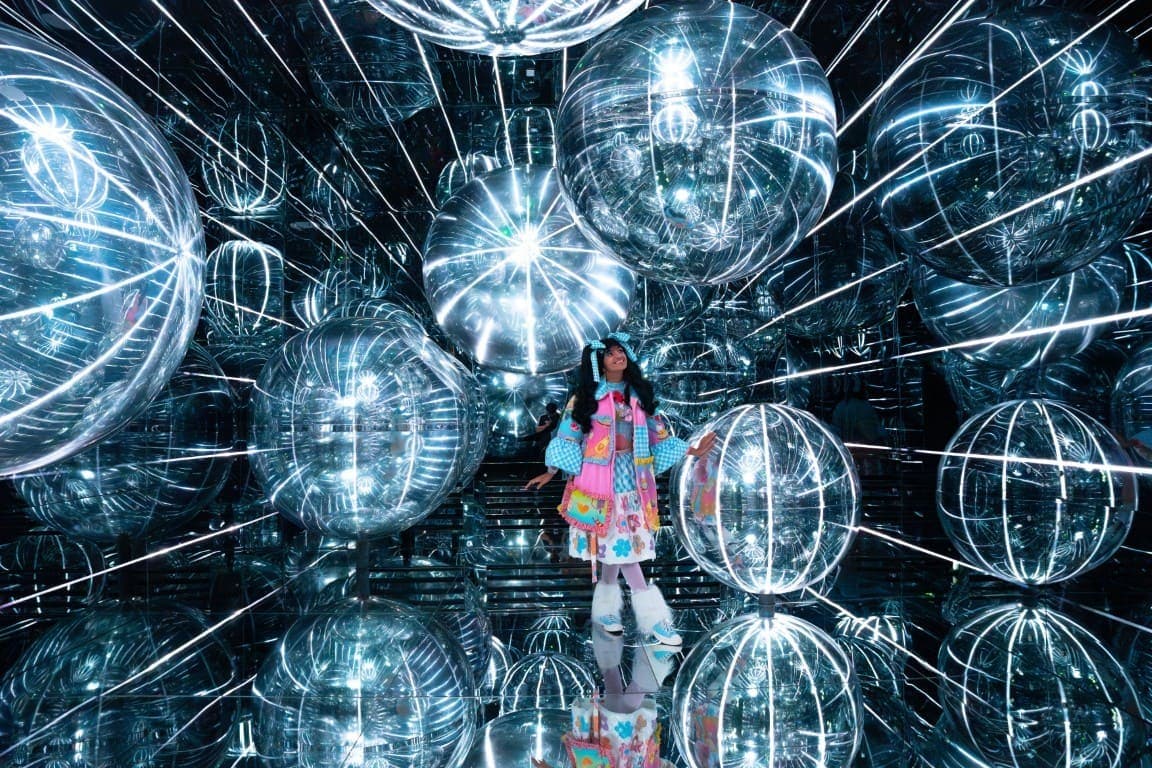 A woman stands in front of a large glowing orb at House of Hype in Dubai, creating a striking visual contrast.