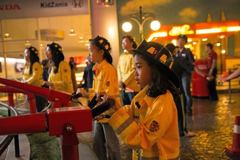 Kids participating in a factory role-play activity at KidZania Dubai, learning how products are made.