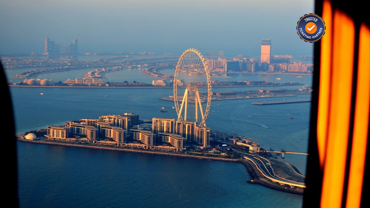 Aerial helicopter view of Ain Dubai observation wheel and Bluewaters Island during a Dubai helicopter tour