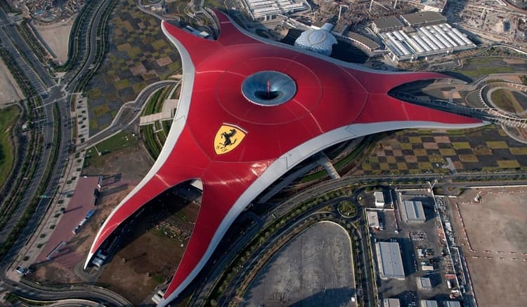 Top aerial view of Ferrari World Abu Dhabi showcasing the iconic red Ferrari-shaped roof on Yas Island.