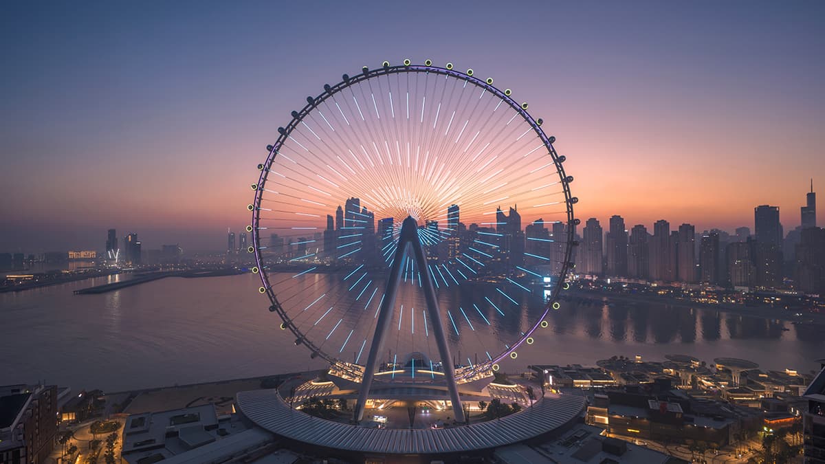 Ain Dubai observation wheel illuminated at sunset with Dubai Marina skyline and waterfront views