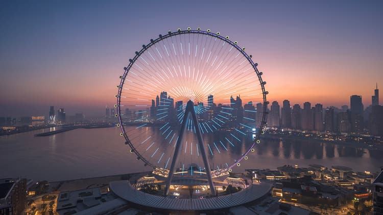 Ain Dubai observation wheel illuminated at sunset with Dubai Marina skyline and waterfront views