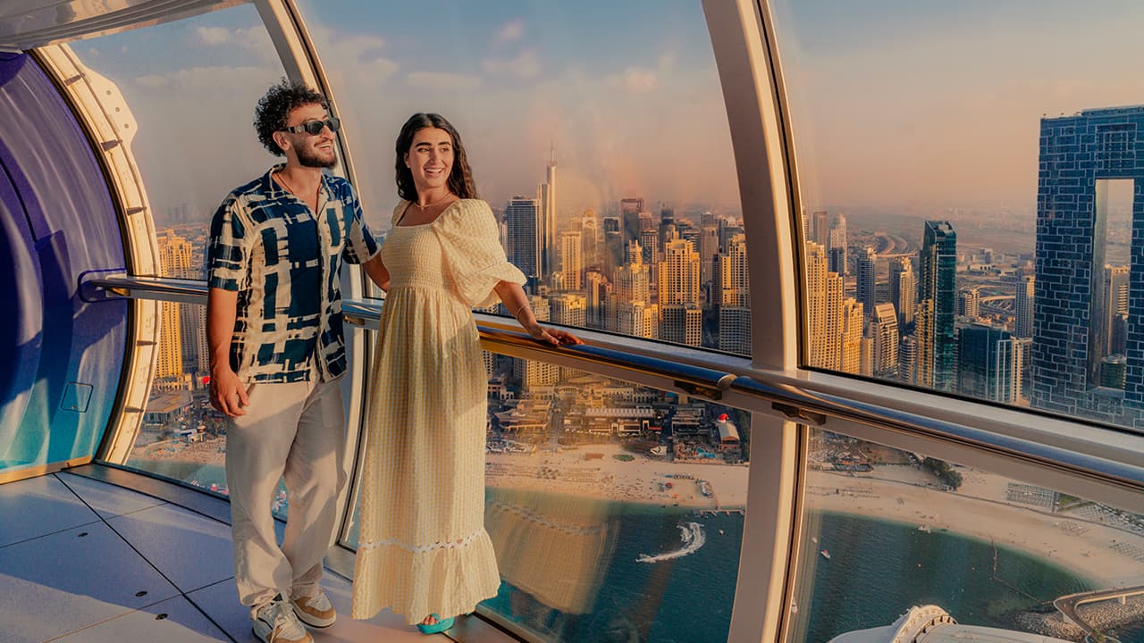 Couple enjoying panoramic Dubai skyline views from inside an Ain Dubai observation wheel cabin at Bluewaters Island.