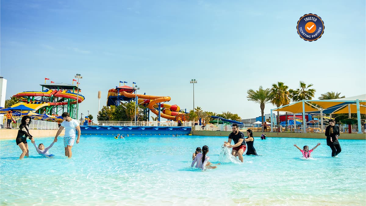 A vibrant water park scene featuring large, twisting orange and yellow slides.