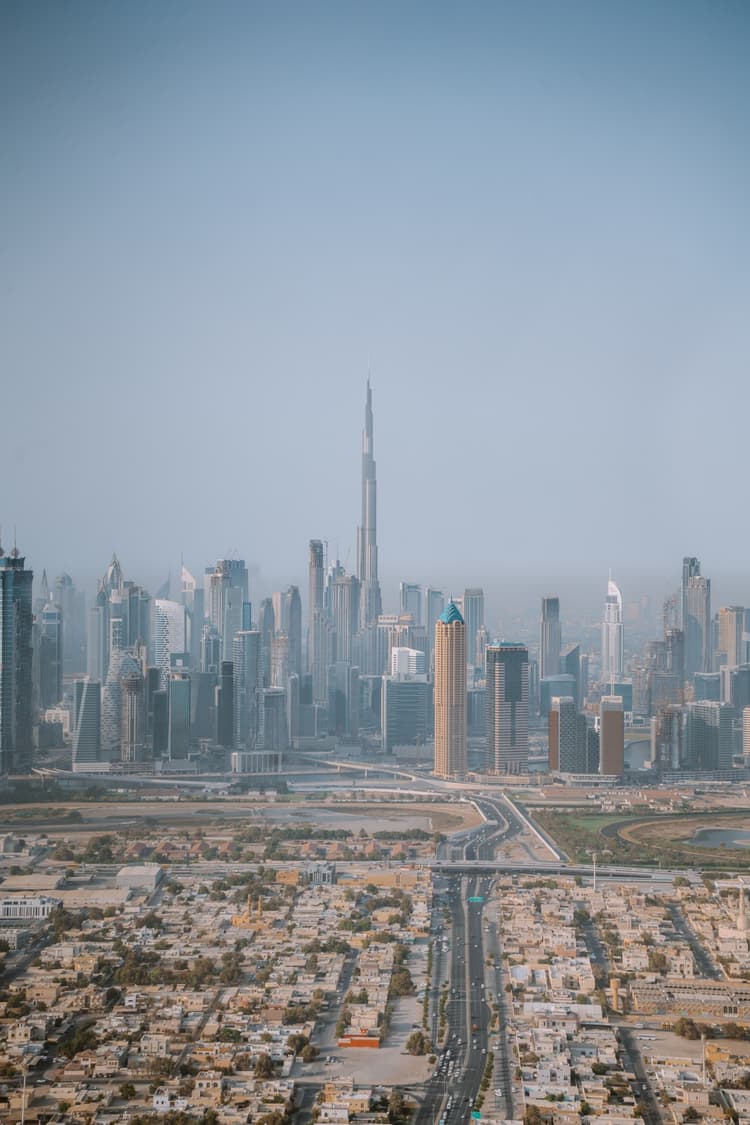 Aerial view of a modern cityscape with tall skyscrapers, including a central towering structure.